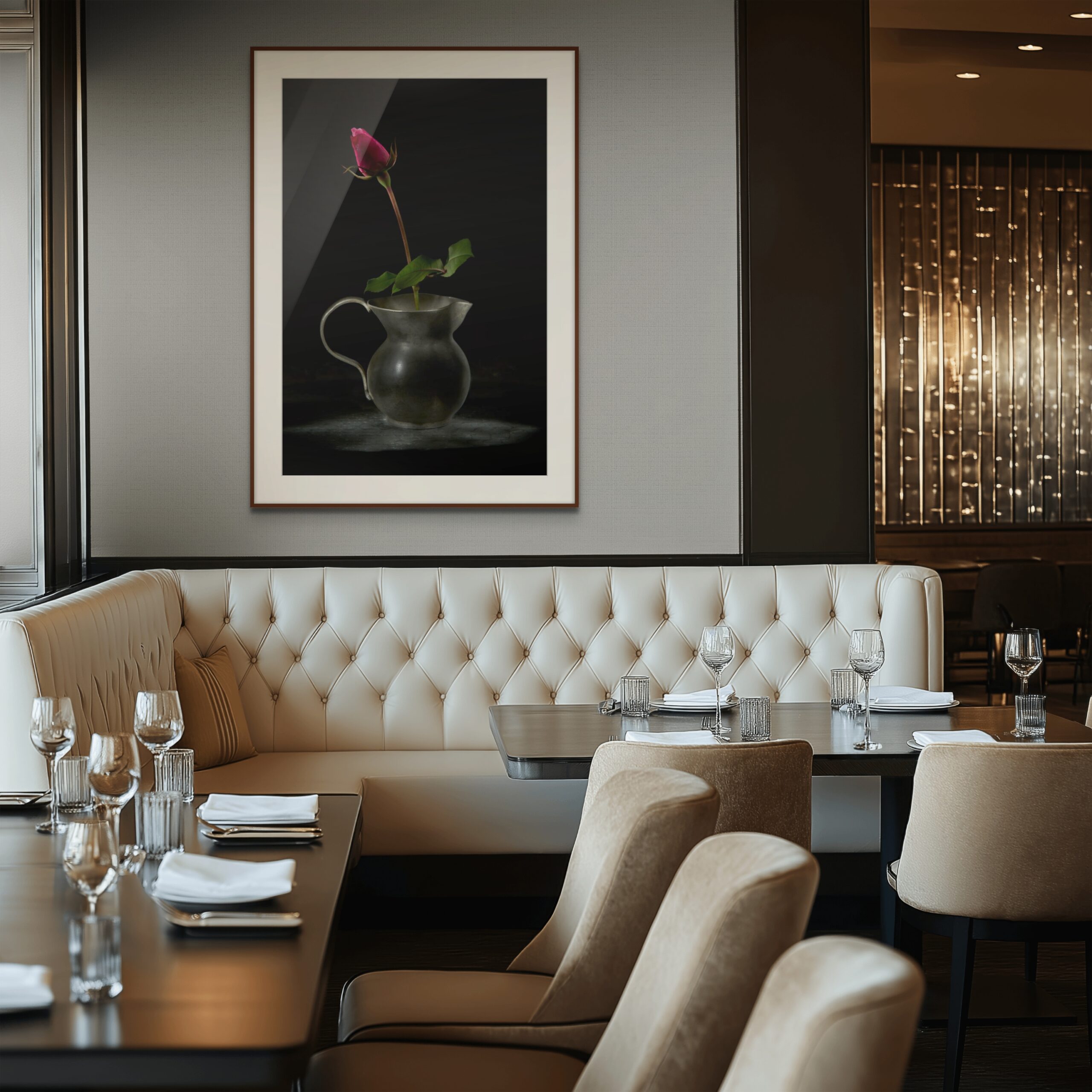 Mockup di interior design per un ristorante di lusso o una lounge area. Sopra una seduta capitonné in pelle color panna è esposta la fotografia fine art "L'Anima e il Tempo" di Antonio Milesi, raffigurante una rosa in un vaso di metallo su sfondo scuro. Interior design mockup for a luxury restaurant or lounge area. Above a cream-colored tufted leather booth, the fine art photograph "L'Anima e il Tempo" (The Soul and Time) by Antonio Milesi is displayed, featuring a rose in a metal vase against a dark background.